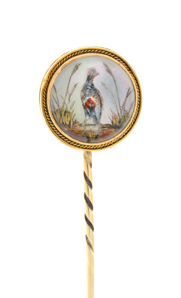 An early 20th century gold Essex rock crystal stick pin, depicting a game bird.