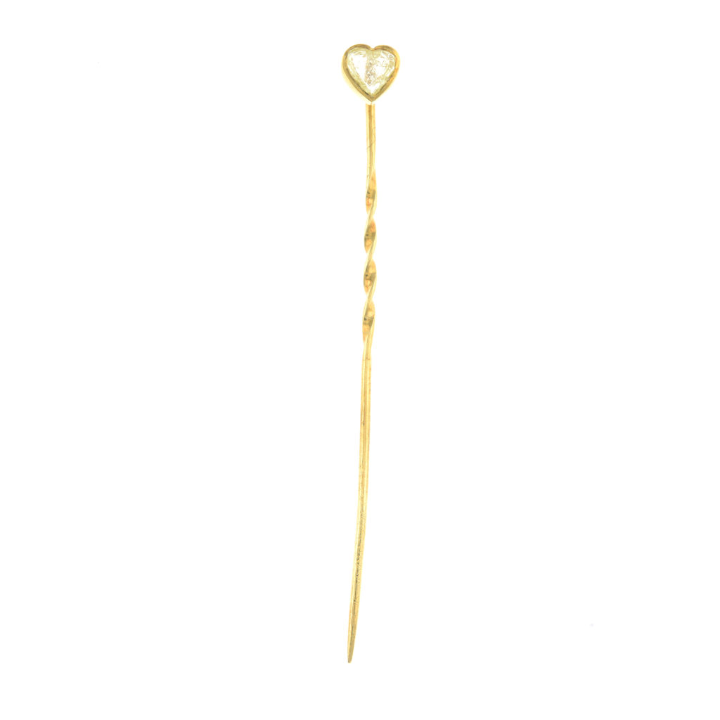 A heart-shape stickpin, containing a diamond macle.