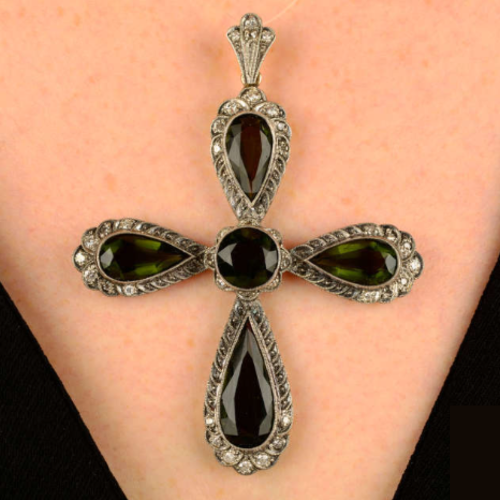 A moldavite and single-cut diamond cross pendant.